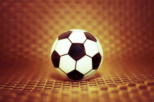 A toy soccer ball on an artificial background. Concept of the game of football