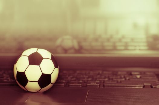 Souvenir soccer ball on the laptop keyboard. The concept of a football match