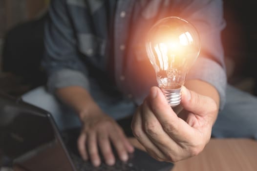 Hand of male holding a light bulb for innovation and creative concept .