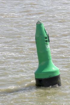 Green buoy as a marker for shipping on the UNESCO protected Wadden Sea in the North of the Netherlands
