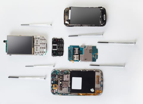 disassembled mobile phone and screwdriver close-up, top view