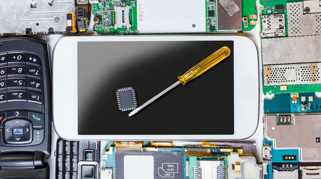 mobile phone with a tool on the background of electronic boards