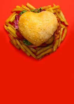 Heart shaped hamburger and french fries, love burger fast food concept, on red background, top view