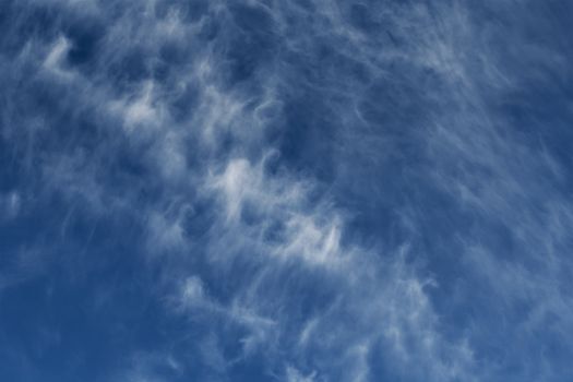 Clear blue sky with plain white cloud with space for text background. The vast blue sky and clouds