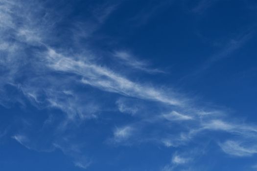 Clear blue sky with plain white cloud with space for text background. The vast blue sky and clouds