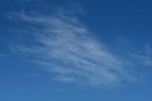 Clear blue sky with plain white cloud with space for text background. The vast blue sky and clouds