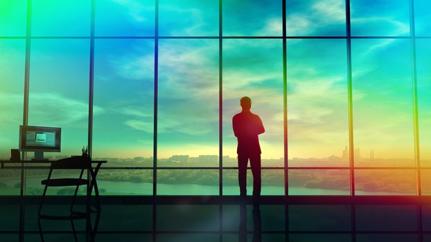 Silhouette of a man in a huge office in front of large windows.