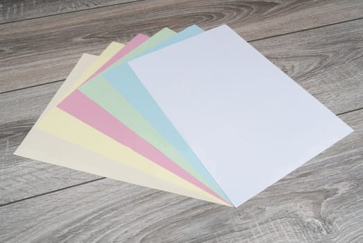 sheets of colored paper on a wooden table