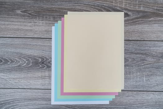 sheets of colored paper on a wooden table