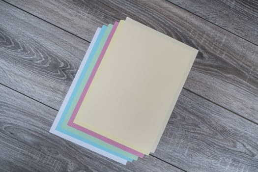 sheets of colored paper on a wooden table