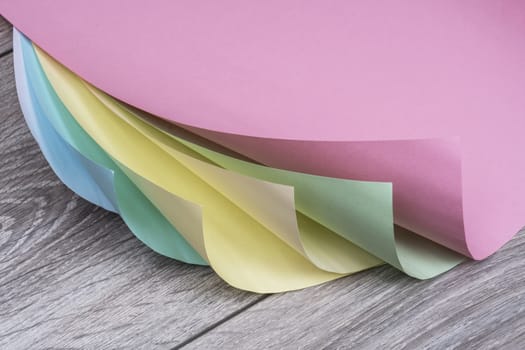 sheets of colored paper on a wooden table