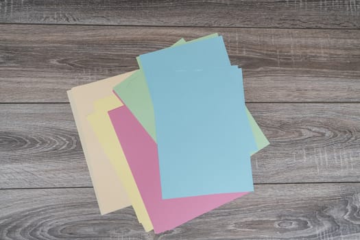 sheets of colored paper on a wooden table