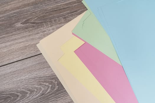 sheets of colored paper on a wooden table