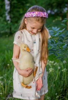 Girl having fun and holding duckling 