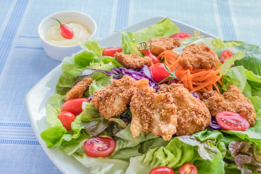 fresh organic salad with deep fried pork in white bowl served with cream sauce
