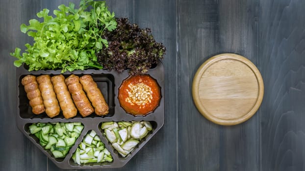 top view of roasted pork served with spicy sauce and vegetable (Nam Neung) on wooden background