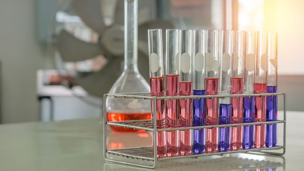 Different laboratory test tubes with colored liquid and with reflection