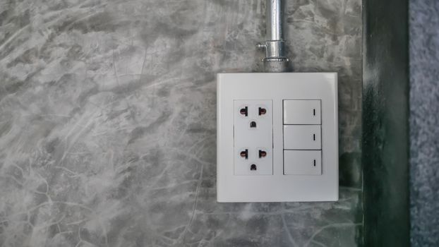 electric plug and switch on gray wall
