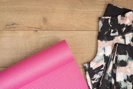 Pink Yoga Mat And Leggings In Flat Lay Style On A Wooden Background. Top View. Fashion Trendy Trainers, Hipster Set. Fitness Concept, Active Lifestyle, Body Care Concept