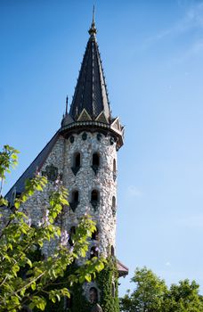 Beautiful old fairy-tale castle near Burgas, Bulgaria. Tower of the castle, green flower garden 