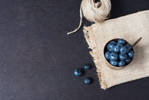 Fresh blueberries dark picture with copy space on left. Fresh fruits, berries in an old copper cup, bowl. Dark Styled Stock Photo, Black Background