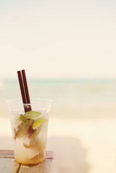 Mojito cocktail on the beach, blurred beach background. Sun, sun haze, glare