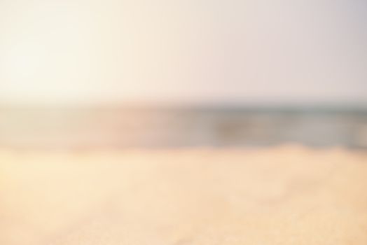 Blur summer white sand beach with sea water. Abstract bokeh blurred on colorful background. Space For Text. Sun, sun haze, glare