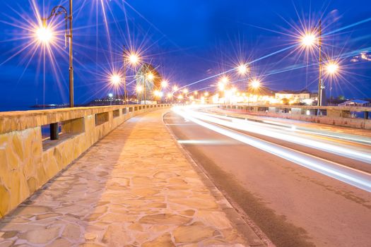 Ancient town of Nesebar UNESCO - protected. Road, night lights, windmill. Car light trails. Long exposure photo taken