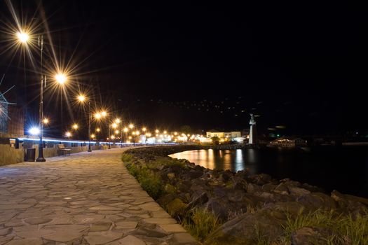 Ancient town of Nesebar UNESCO-protected. Night photography. Stone path to the beach, city lights