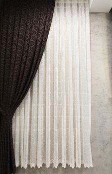 Beautifully draped long curtain on the window in the room. Close up of piled curtain. Luxury curtain, home decor. Brown panels. White lace drapery