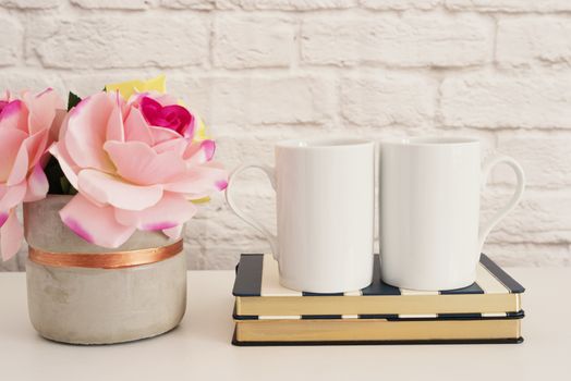 Two Mugs. White Mugs Mockup. Blank White Coffee Mug Mock Up. Styled Photography. Coffee Cup Product Display. Two Coffee Mugs On Striped Design Notebooks. Vase With Pink Roses