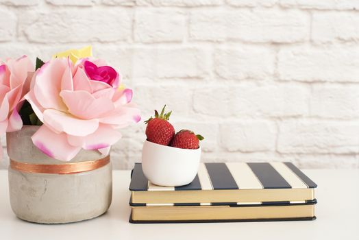 Pink Roses Mock Up. Styled Photography. Brick Wall Product Display. Strawberries On Striped Design Notebooks. Vase With Pink Roses