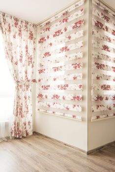 Warm light through sheer white tulle and vintage floral curtains, blinds with red roses in the bedroom. Interior design