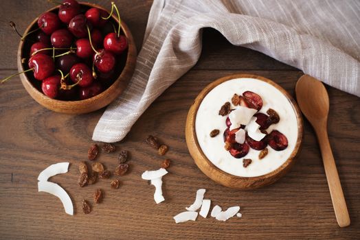 Oat Flakes With Yogurt And Fruits. Cherries, Raisins And Coconut Chips. Overnight Breakfast. Healthy Food Concept. Fitness Mood Diet. Summer Light Snack. Dark Wooden Background