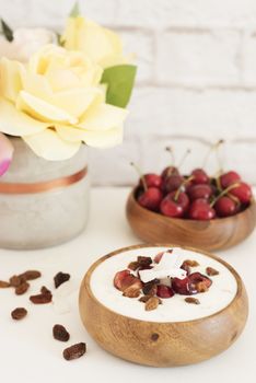 Oat Flakes With Yogurt And Fruits. Cherries, Raisins And Coconut Chips. Overnight Breakfast. Healthy Food Concept. Fitness Mood Diet. Summer Light Snack. Bright Brick Wall Background. 