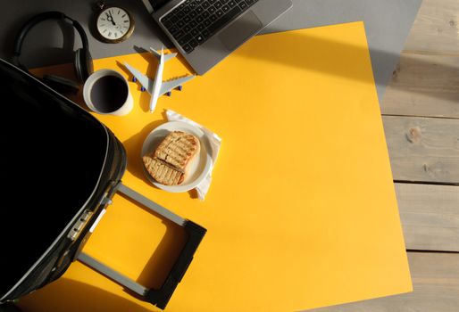 Accessories including open suitcase; laptop, clock with grilled sandwich view from above