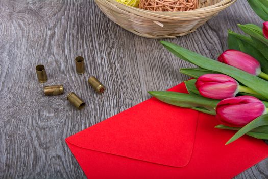Red envelope with tulips on a wooden table