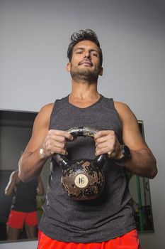 man in his thirtie holding a kettlebell