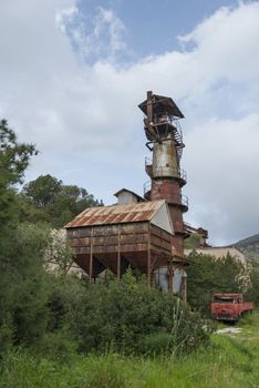 Golfo Aranci,Italy,08-April-2018:old abandonned urban metal mine with rusty red car left by the workers long time ago,the mine is closed years ag and the rubbish is still there