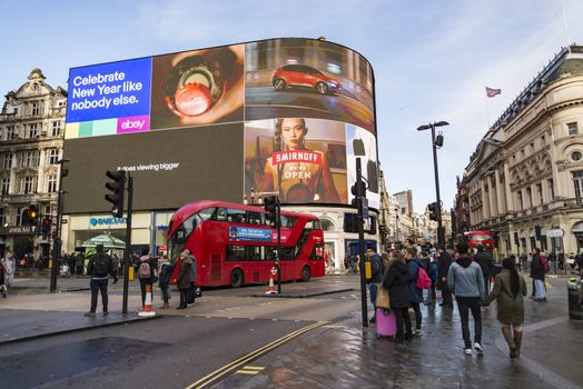 LONDON - DECEMBER 29: view of Piccadilly Circus with cabs , buses and crowds on December 29, 2017 in London UK. Famous advertisements have been here for at least 20 years and are considered symbols of famous square.