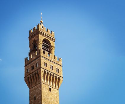 Detail of the bell tower of Palazzo Vecchio in Florence with the large windvane shaped like a heraldic lion holding the pole surmounted by the Florentine lily