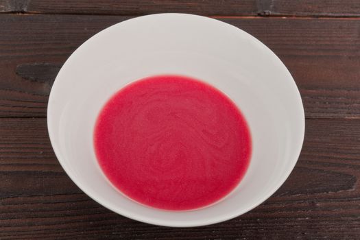 Beet soup with wine on a wooden table