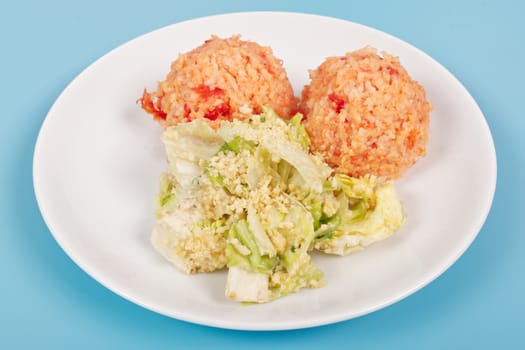 Tomato rice and salad on a blue background