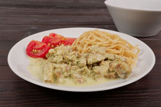 Spaghetti with tempeh and herb sauce on a wooden table