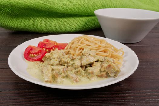 Spaghetti with tempeh and herb sauce on a wooden table