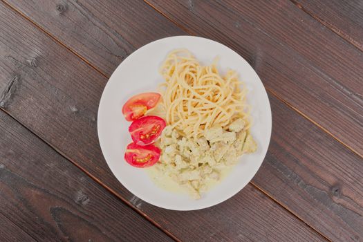 Spaghetti with tempeh and herb sauce on a wooden table