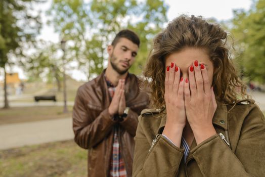 Handsome young man and woman crying in relationship problems.