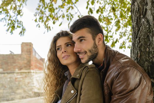 Good-looking young man is holding his attractive girlfriend from the back