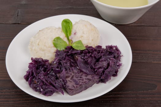 Tempeh with red cabbage and sorghum on a wooden table