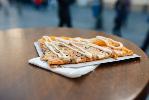 Delicious italian pizza slice served on wooden table.